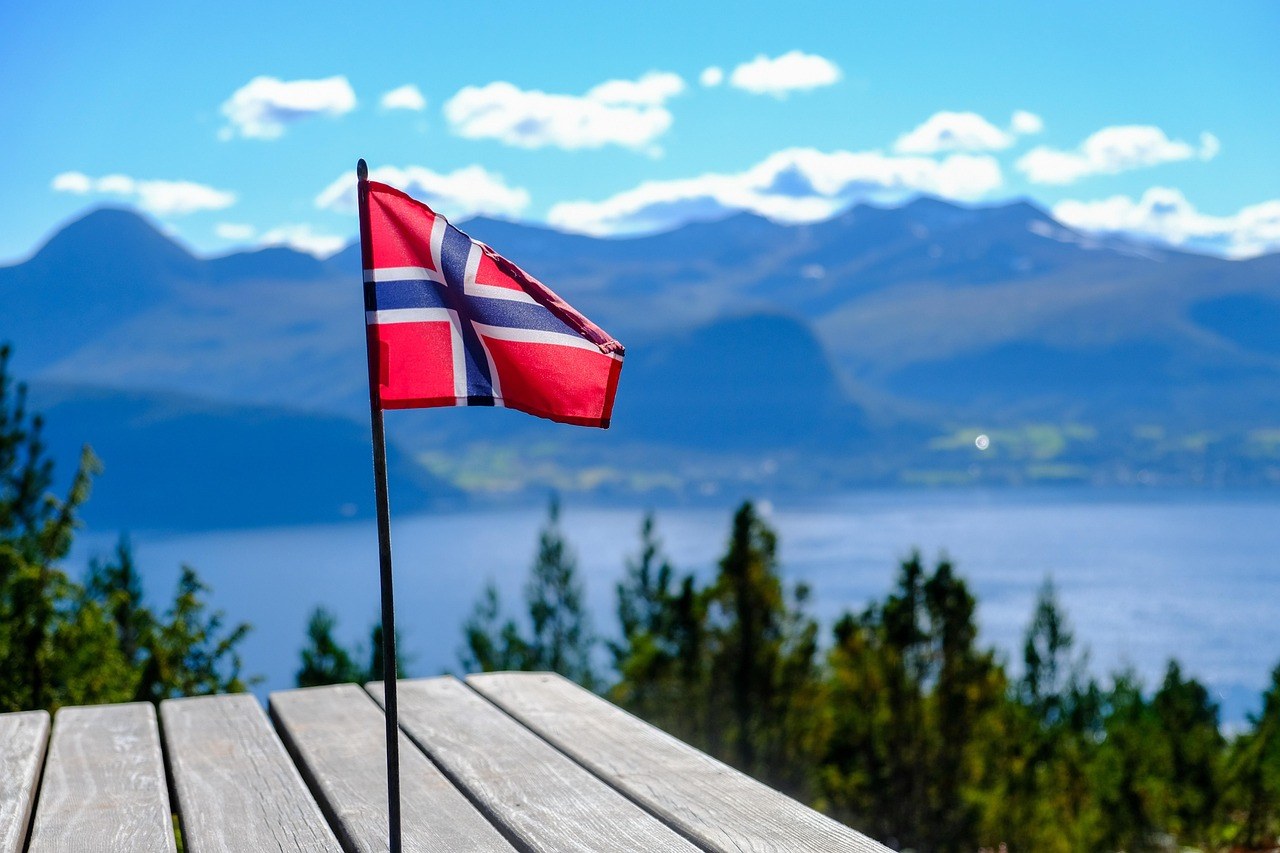 Flaga Norwegii na tle fiordu – Fundusze Norweskie dla firm